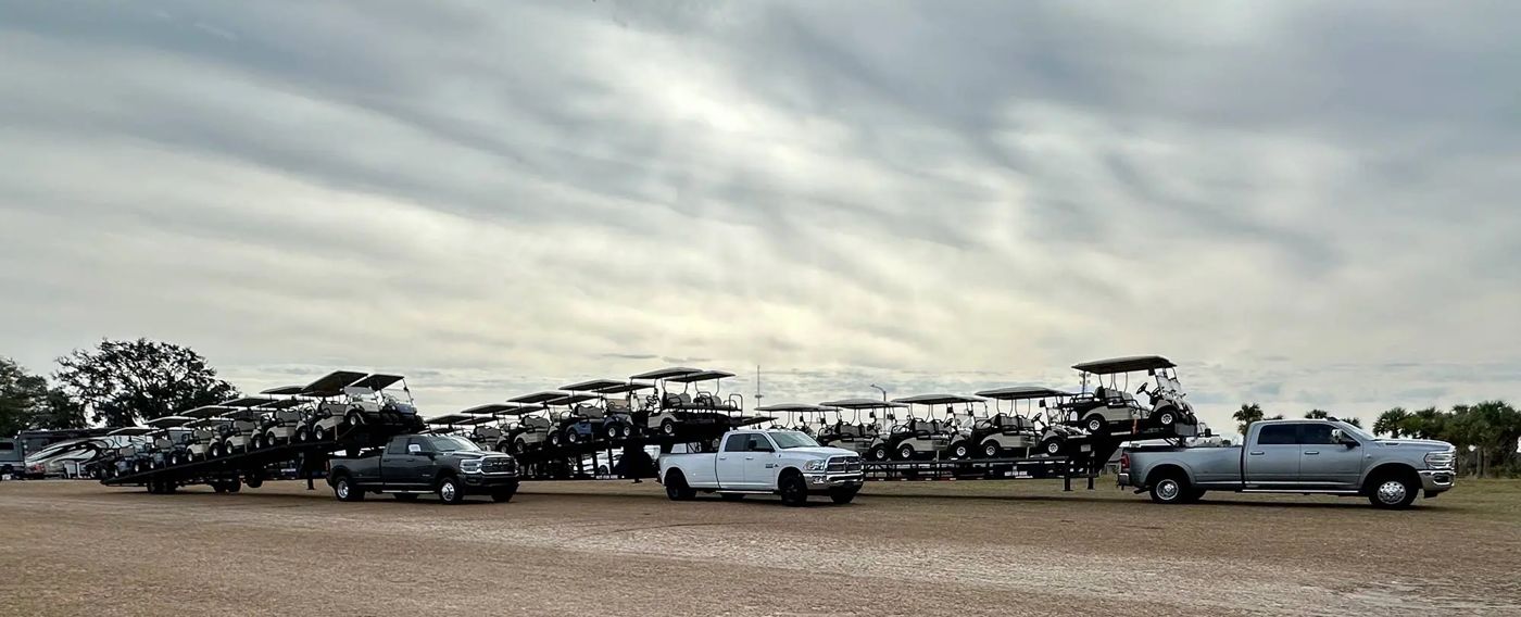 Masters trucks hauling trailers of carts